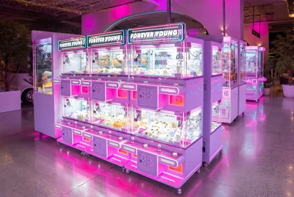 Pink claw machines filled with prizes at Forever Young